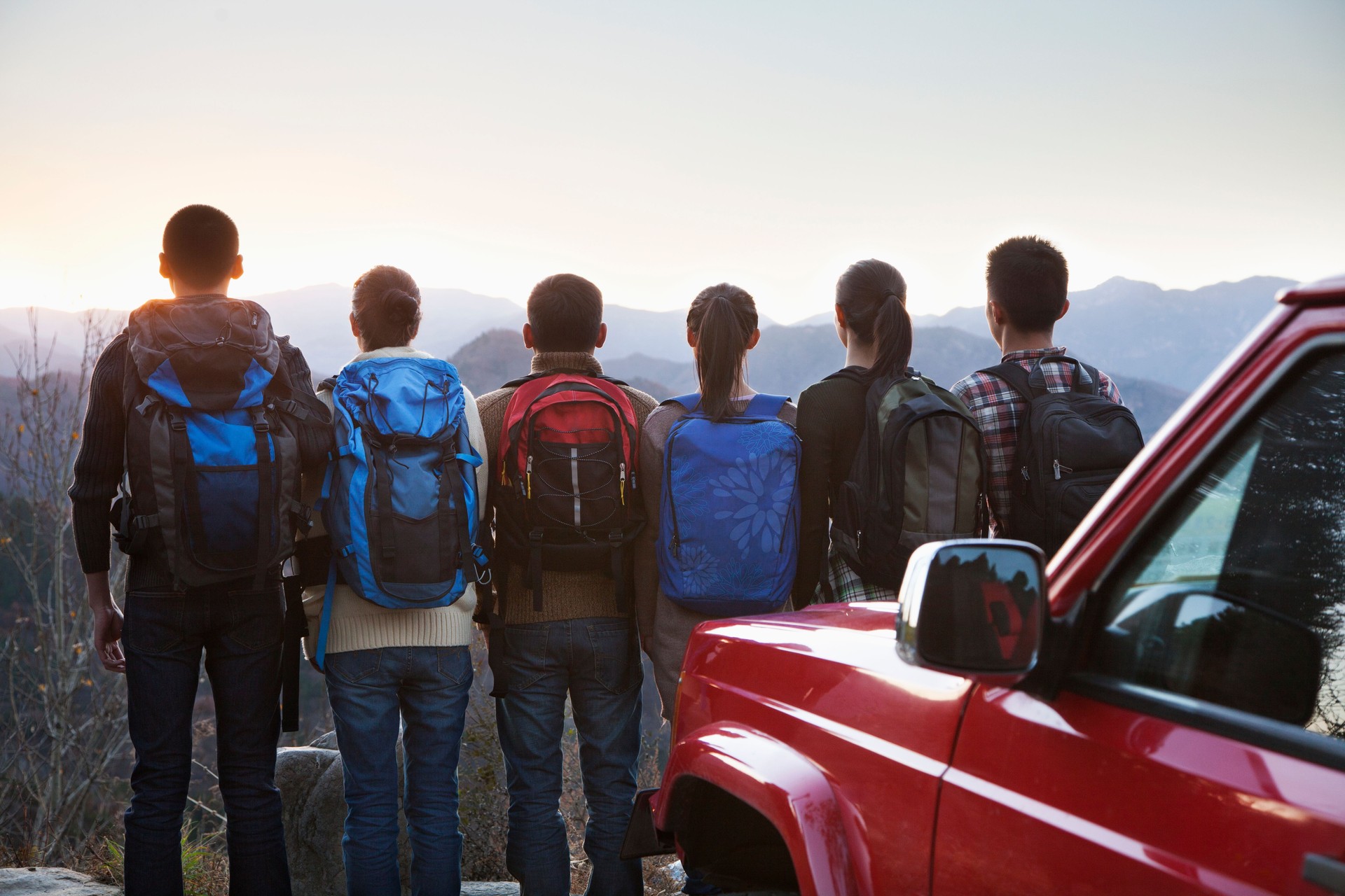 Group of people next to car and looking at mountains